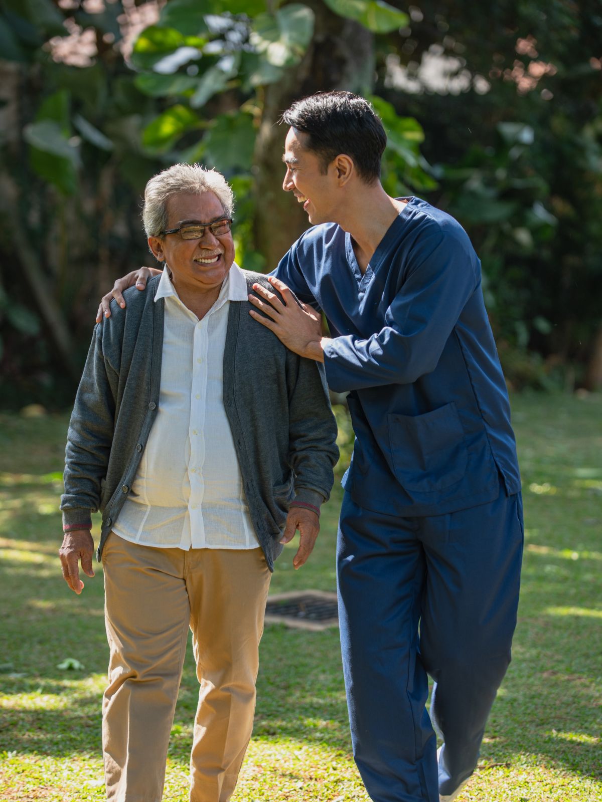 Professional home care support helping an elderly woman walk outdoors